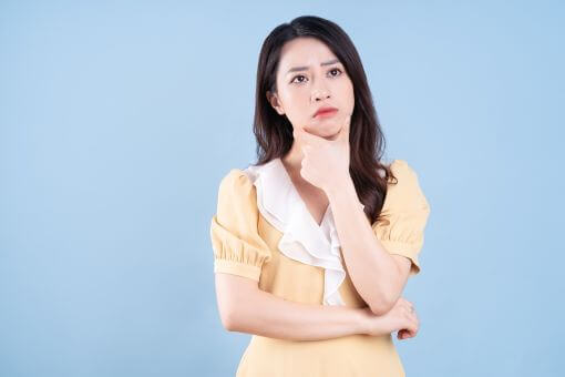 顎に手をあてて悩む女性